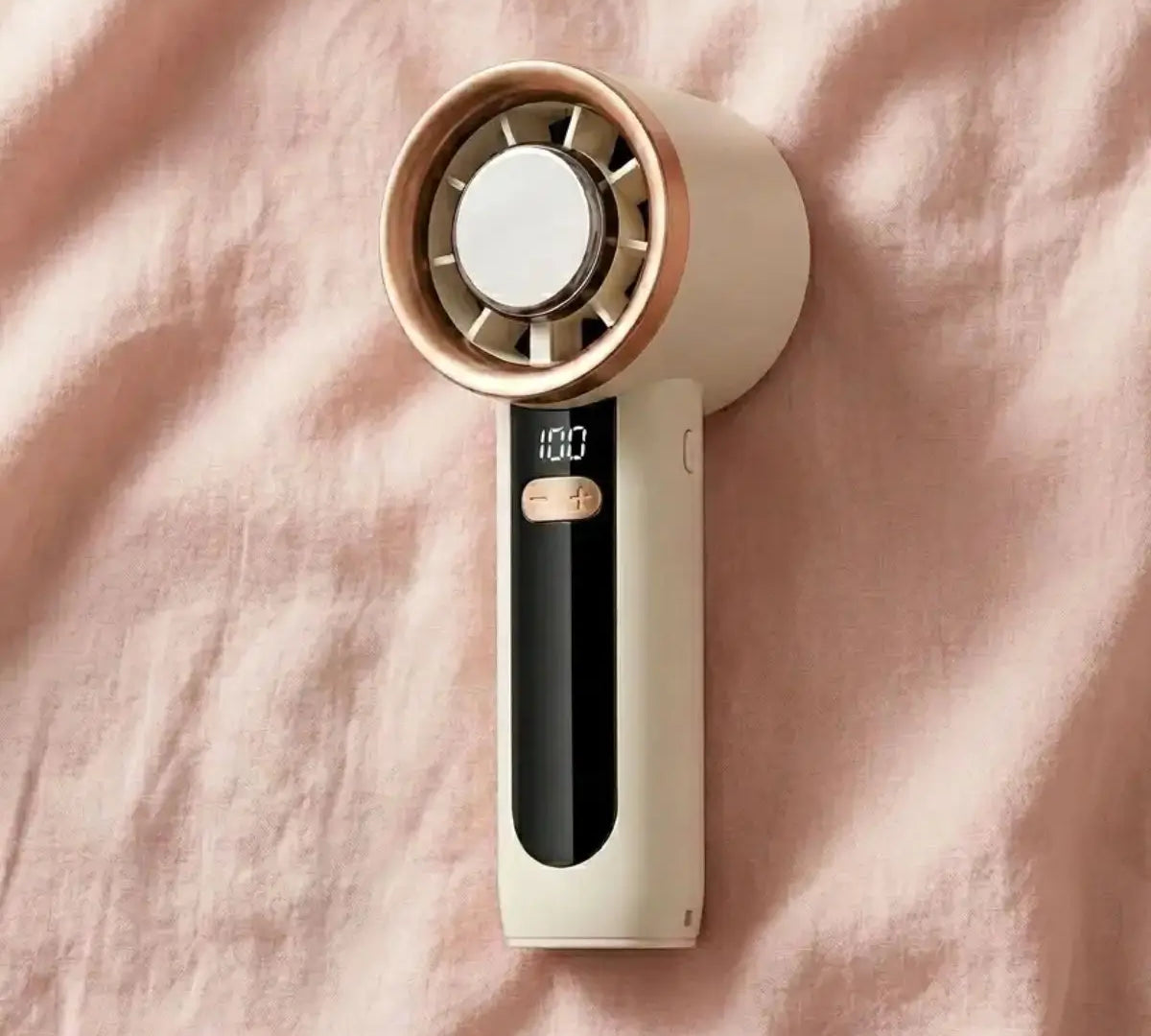 A pink and white rechargeable handheld fan, compact enough for a purse, used for hot flash relief during breast cancer treatment.
