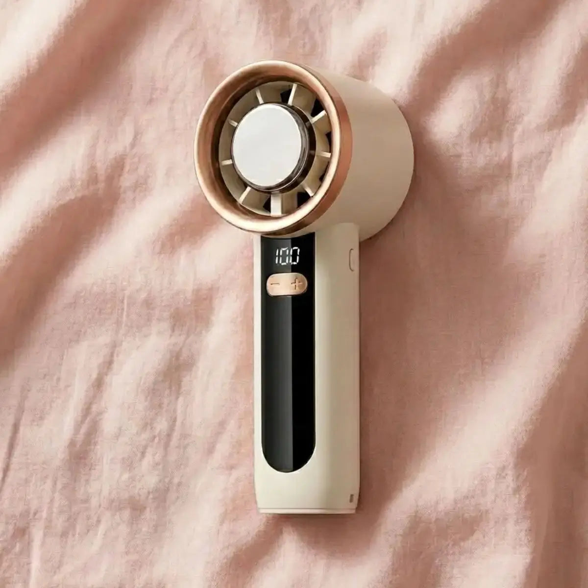 A pink and white rechargeable handheld fan, compact enough for a purse, used for hot flash relief during breast cancer treatment.