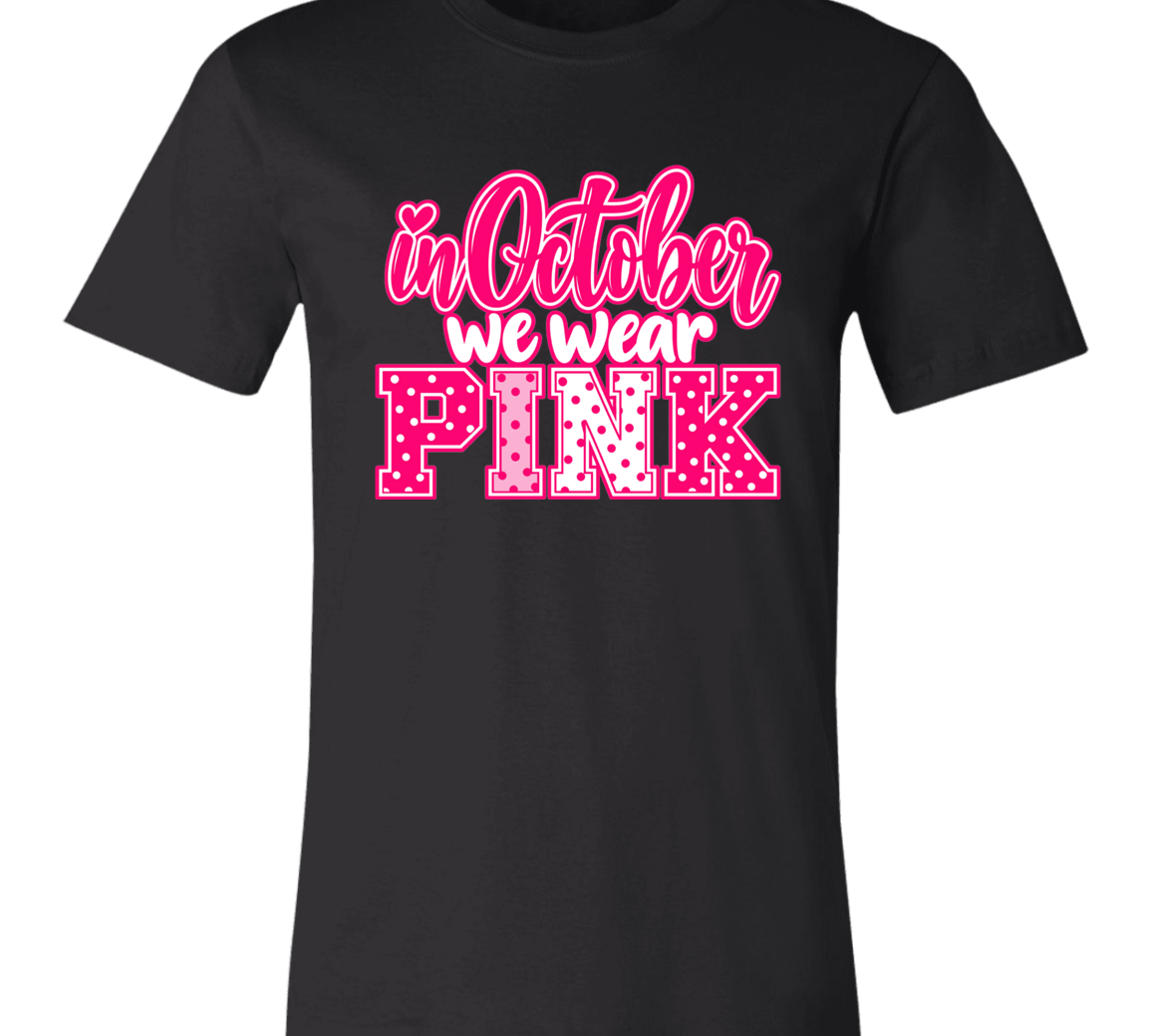 a black graphic t-shirt that reads 'in October we wear PINK' in pink and white lettering