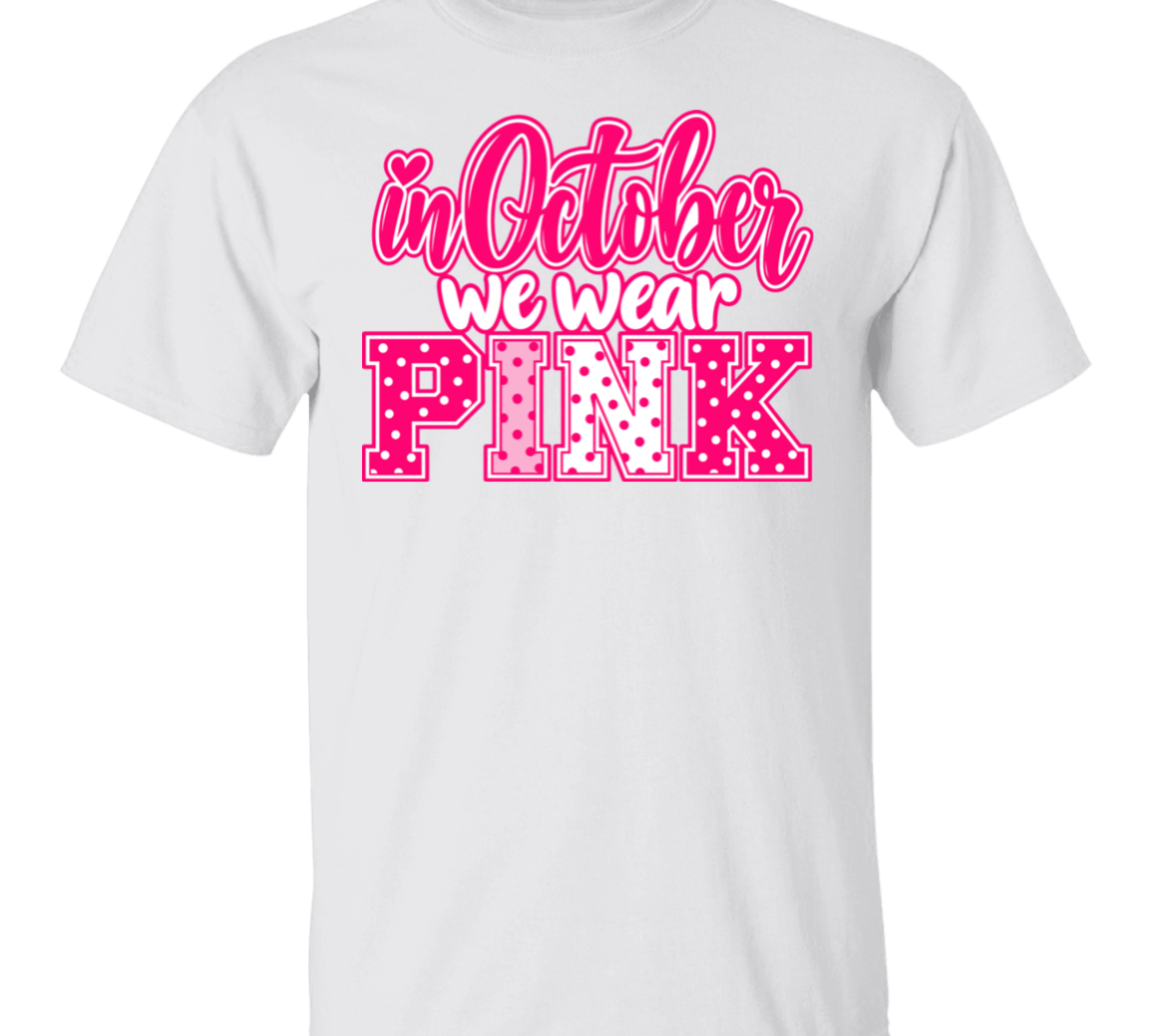 white tshirt with the words, "in October we wear Pink" with the letters in pink and white polka dots.