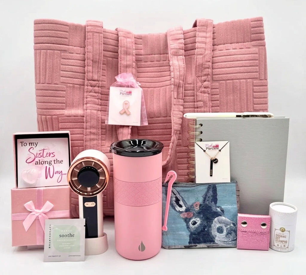 The Pink Luxe Box open and styled, showing 13 comfort, beauty, and recovery essentials curated for a woman facing breast cancer.