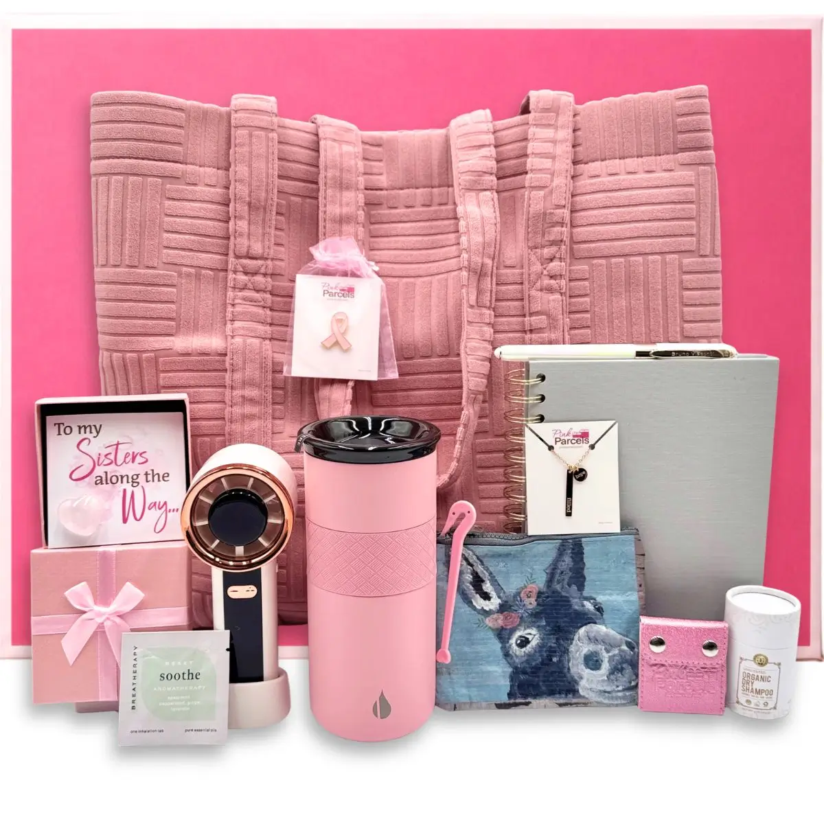 A collection of premium pink comfort gifts including a quilted tote bag, insulated tumbler, and signature gift box from Pink Parcels for women facing breast cancer.